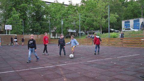 Chisinau, Republic of Moldova, May 30th, 2020: children wearing casual clothing playing football AKA soccer game in residential district.