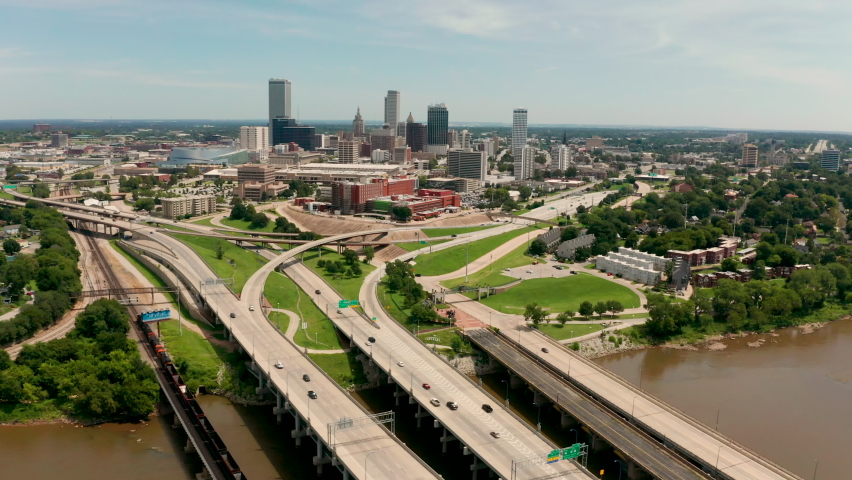 Fast motion cars and trucks traveling into and out of Tulsa from an aerial perspective