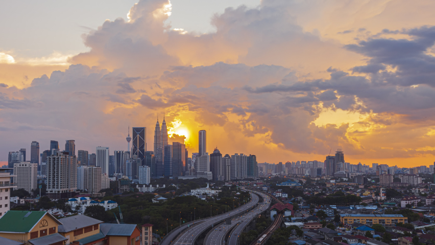 Kuala Lumpur Time Lapse: Sunset of cityscape during a golden sunset overlooking an elevated highway in Kuala Lumpur city. Malaysia. Cinematic. Pan down motion timelapse. Prores 4KUHD Royalty-Free Stock Footage #1059165920