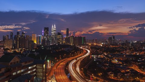Kuala Lumpur Time Lapse: Sunset of cityscape during a golden sunset overlooking an elevated highway in Kuala Lumpur city. Malaysia. Cinematic. Pan down motion timelapse. Prores 4KUHD