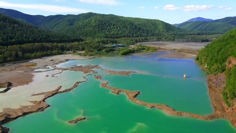 View from above. The camera flies over a chemical lake with turquoise water. Tailings dump of the Khrustalnenskiy mining and processing plant in the Primorsky Territory