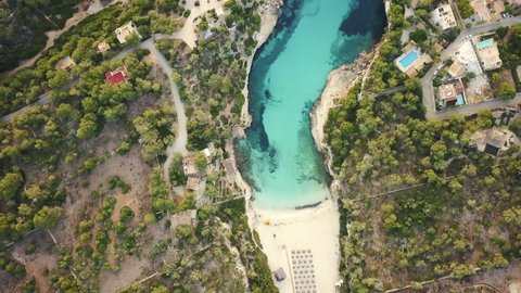 Birds eye view of the beautiful Cala Llombards with clear blue turquoise water at the east coast of Mallorca in 4k - drone video