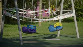 4k video of police emergency tape on an empty swing in a children's playground in a park during the coronavirus / covid-19 pandemic.