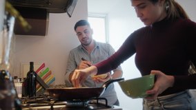 Young couple cooking food together at home with new recipe. Happy man and woman preparing omelette for lunch. Husband and wife smiling in kitchen. Married partners and lifestyle - Powered by Shutterstock - Get 15% off with code: PIKWIZARD15