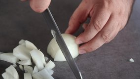 Chef cutting white onion using a kitchen knife