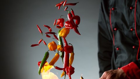 Super slow motion of flying chilli peppers from wok pan, chef closeup. Filmed on very high speed cinema camera, 1000 fps.