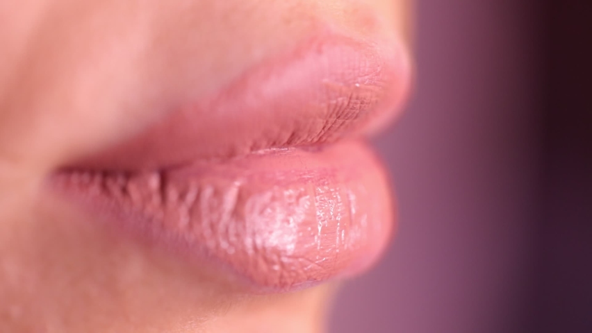 Make up artist applying lipstick. close-up of the lips of a young woman, professional makeup artist with a brush applies natural color lipstick. fashion backstage. beauty saloon. Pink background Royalty-Free Stock Footage #1059194285