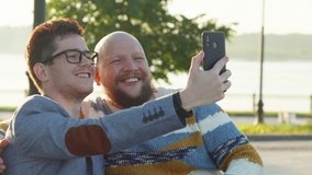 Guys Smile and Laugh in Love. Cute Male Homosexual Gay Couple Spend Time Together in Park. Men Taking Selfie on Smartphone Dating at Sunrise. LGBTQI, Pride Event, LGBT Pride Month, Gay Pride Symbol - Powered by Shutterstock - Get 15% off with code: PIKWIZARD15