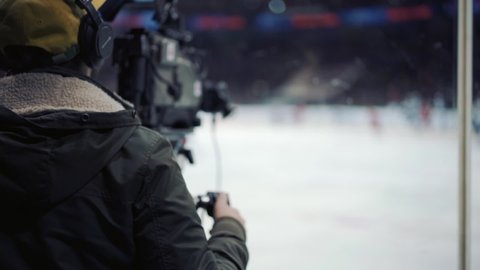 Cameraman shooting ice hockey game.