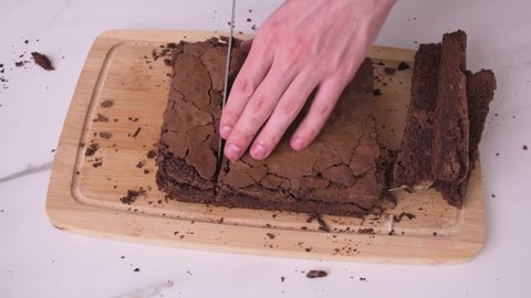 Cutting brownies portion on wooden board side view