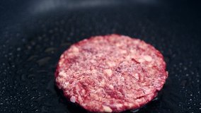 Fresh red beef meat patty frying on hot pan in fast food restaurant kitchen for dinner meal.Traditional American fastfood burger cooking in closeup video clip.Delicious pork cutlet fried for hamburger