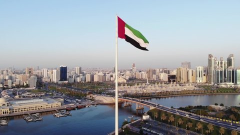 Sharjah, Aerial view of UAE flag waving in the sky over Flag Island in Sharjah. UAE flag day, Sharjah Flag Island