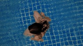 Young woman swimming in open swimming pool. Outdoor activities. Healthy lifestyle. Top view aerial video 4k.