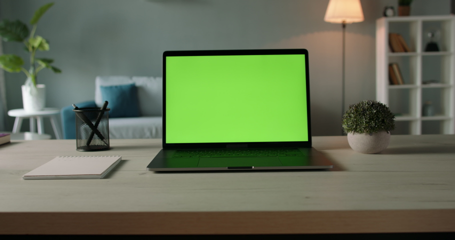 Modern laptop with mock up chroma key green screen on table of living room, desk set up for work at home - technology concept close up zoom 4k video template Royalty-Free Stock Footage #1059221171