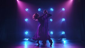 A romantic couple in elegant outfits is dancing the waltz. Silhouettes of a tender couple of dancers in the spotlight. Slow motion. - Powered by Shutterstock - Get 15% off with code: PIKWIZARD15