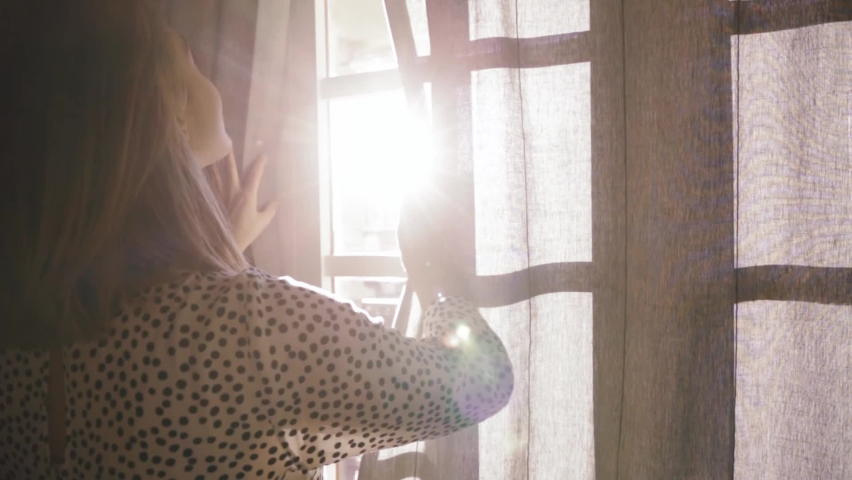 Close up at sunlight back view of silhouette young woman opens the curtains looking enjoying light and city view in the morning nature old city slow motion Royalty-Free Stock Footage #1059229883