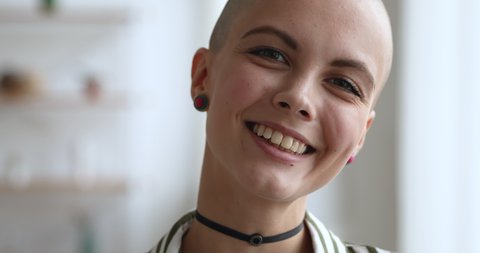 Dreamy young pretty bald woman wear choker earrings smile look at camera close up face. Stylish trendy female portrait. Healthy recovered after oncology disease girl start new fulfilling life concept