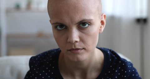 Close up face bald woman sit indoor look at camera, lost of hope feels despair. Malignant inoperable tumor, ineffective treatment, addicted female, HIV AIDS incurable disease person portrait concept