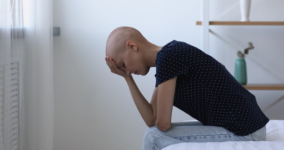 Bald after chemotherapy woman sit on bed bowing head feels hopeless and desperate due cancer incurable disease, malignant growth of tumour, loss of hope, unsuccessful ineffective treatment concept