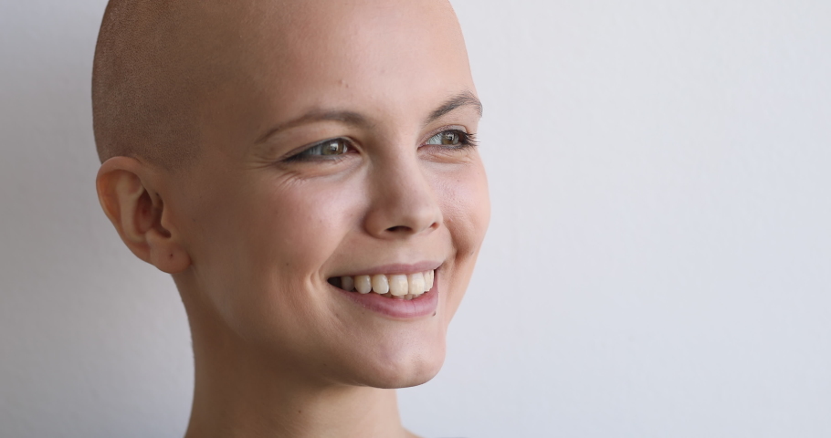 Natural beauty, cancer patient recovery, believe in victory over disease concept. Close up face bald young woman pose on gray studio background having wide charming smile looking at camera feels happy Royalty-Free Stock Footage #1059236150