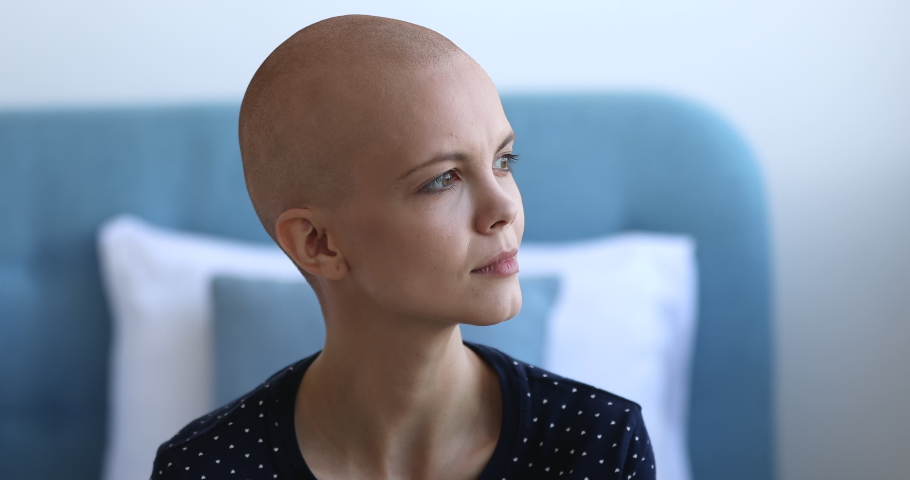 Close up view hairless bald after chemotherapy 20s female sit indoors feels skeptic about treatment lost on sad desperate thoughts feels afraid, scared before operation. Cancer disease patient concept | Shutterstock HD Video #1059236159