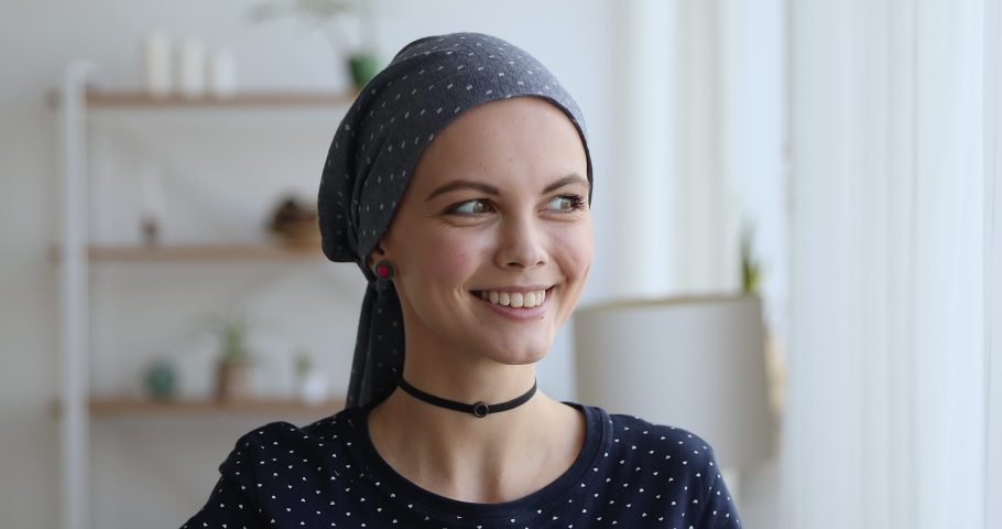 Head shot portrait attractive 30s young woman wear headkerchief on bald head standing in living room smiling look at camera. Oncology disease recovery, successful therapy and rehabilitation concept Royalty-Free Stock Footage #1059236243
