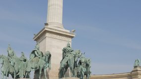 The Millennium Monument on Heroes square in the Hungarian capital city Budapest tilting 4K 2160p UltraHD footage - Hosok ter statues by the day in front of blue sky 4K 3840X2160 UHD tilt video
