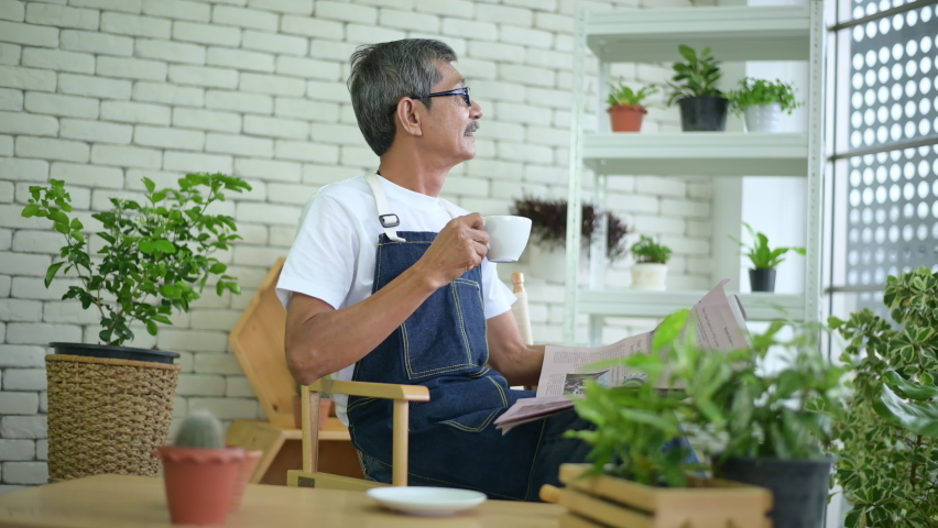 An elderly man is relaxing with coffee and reading Newspaper at his home