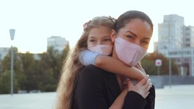 Woman in medical mask, mother holds child in hands on back on street walk in coronavirus epidemic, look lovingly at camera, supports protects baby. Mom hugs daughter in pandemic respiratory virus risk - Powered by Shutterstock - Get 15% off with code: PIKWIZARD15