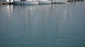 High quality video of a fishing port. Video of boats reflected in the water.