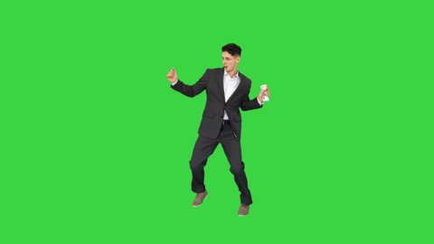 Young happy businessman dancing after counting salary Win dance on a Green Screen, Chroma Key.