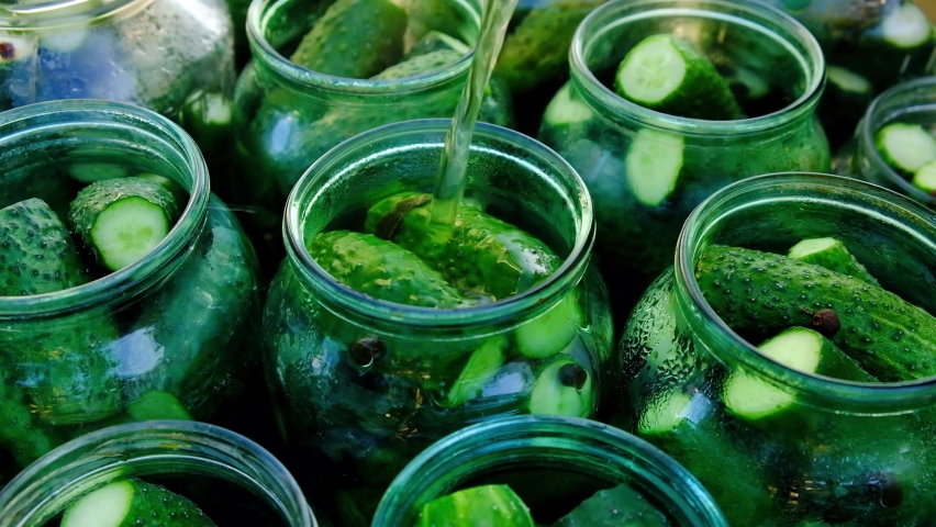 Cucumber pickle is poured into a jar,the process of preparing pickles for the winter. | Shutterstock HD Video #1059257702
