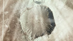 Meteor Crater, also known as Barringer Crater, in the northern Arizona desert of the United States, Seen from Space. Elements of this video furnished by NASA. 