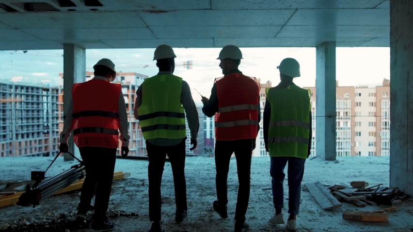 Shot back builders engineers workers in hard hat team walking on construction at sunlight survey urban meeting skyscraper builder architect contractor inspector construction helmet slow motion Royalty-Free Stock Footage #1059264578