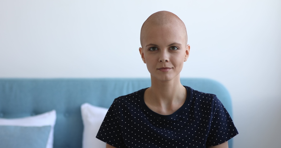 Head shot of enthusiastic bald woman smile looks at camera demonstrate biceps arm. Patient make effort stay alive struggle against oncology disease, shows strength of mind. Fights cancer concept Royalty-Free Stock Footage #1059269930