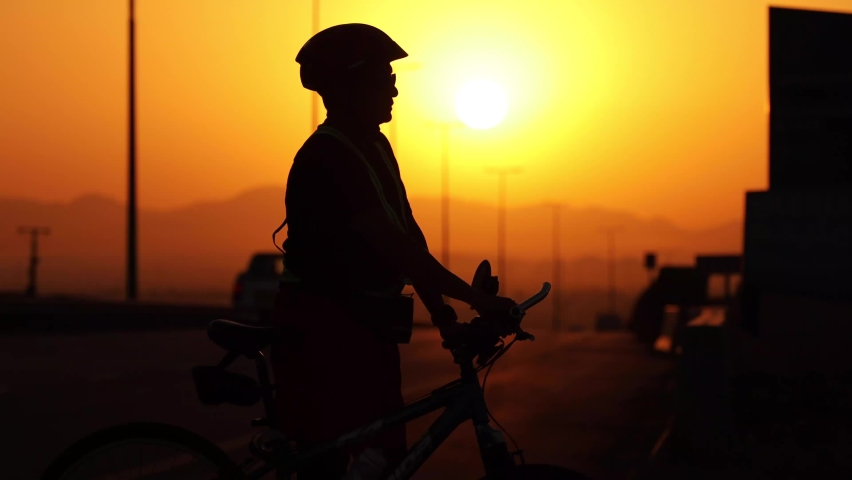 Athlete stopping cycling and having water and washing face
