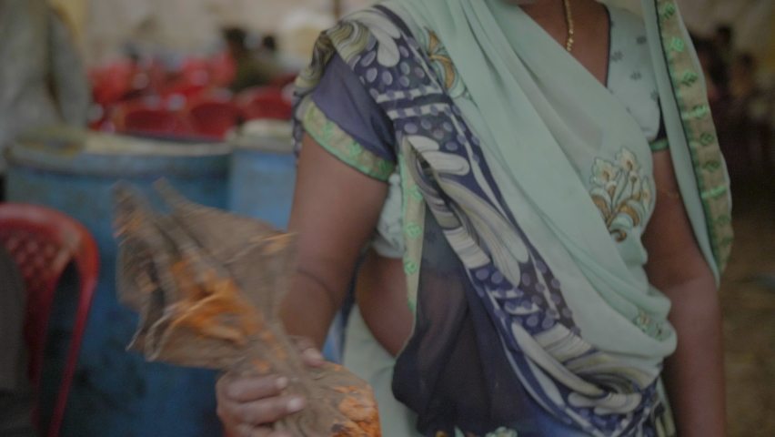 Woman in a dress making traditional sweet orange jalebi snacks on a street food market in central India in slowmotion | Shutterstock HD Video #1059274931