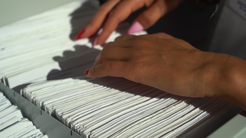 Close up female hands looking for a patient's medical record. Hospital Archive. | Shutterstock HD Video #1059277781