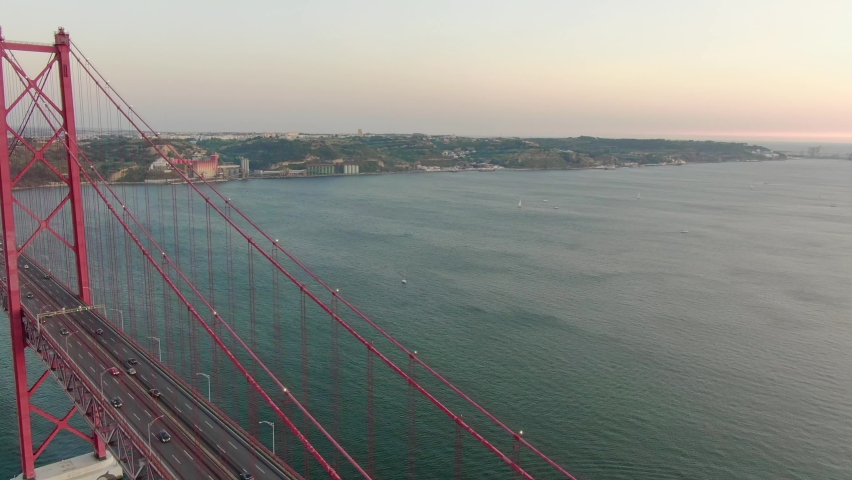 Aerial close up view o cars driving on Lisbon Ponte 25 de Abril suspension bridge at sunset, Portugal Royalty-Free Stock Footage #1059281231