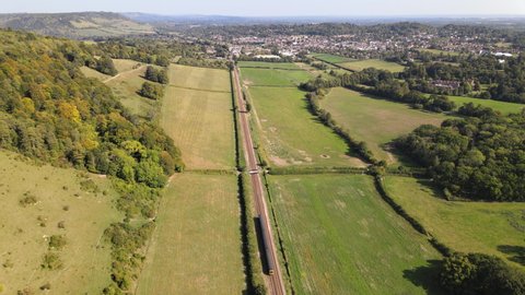 Aerial view of a train travelling through English countryside 