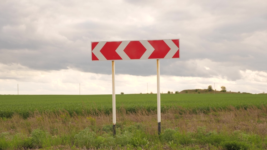 travelers with backpacks come to the road sign at the intersection and choose their route. Teamwork of tourists. Hiking and adventure concept. men are lost, looking for right direction for travel.