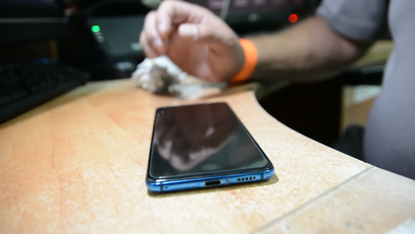 someone changes the protective glass on a mobile phone