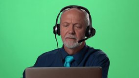Cheerful businessman wear headset making conference video call on laptop. Male professional call center agent, hr manager having distance webcam chat job interview on computer in office. Green screen
