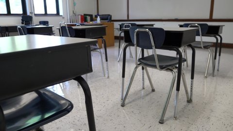 Motion to the left showing empty school classroom with chairs under desks. Concept for pandemic.