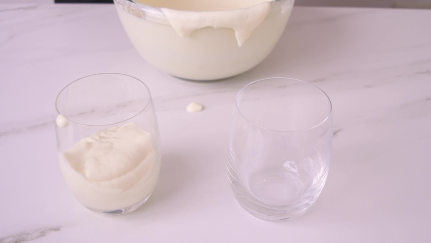 Cream milk cheese lemon pour on glass cup white marble side view | Shutterstock HD Video #1059301337
