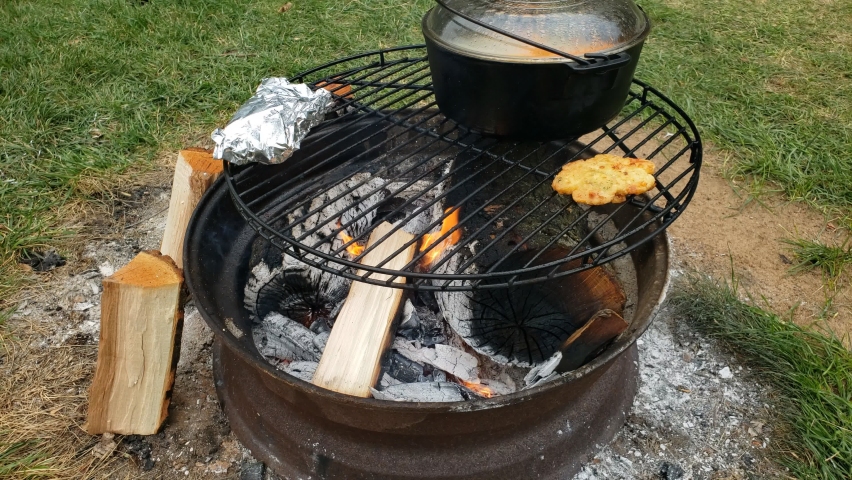 Placing Pieces Of Sausages Onto Stock, Cast Iron Pot For Fire Pit