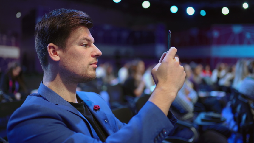 Person take photo on phone in crowded audience business forum. Conference business man with mobile. Seminar for viewer auditorium. group people listen speaker speech. Taking photography scene on phone