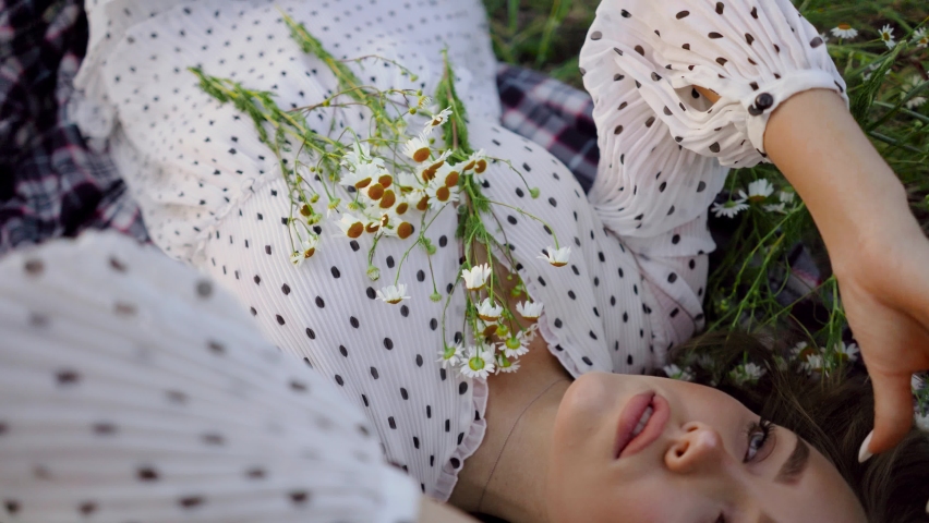 Woman, girl lying in chamomile field. Summer vacation. the view from the top