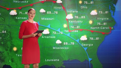 Weather News Studio Female Meteorologist Points at Weather Map.
