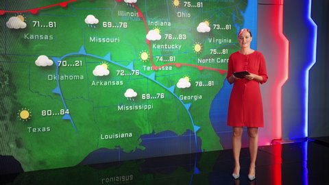 Weather News Studio Female Meteorologist Points at Weather Map.